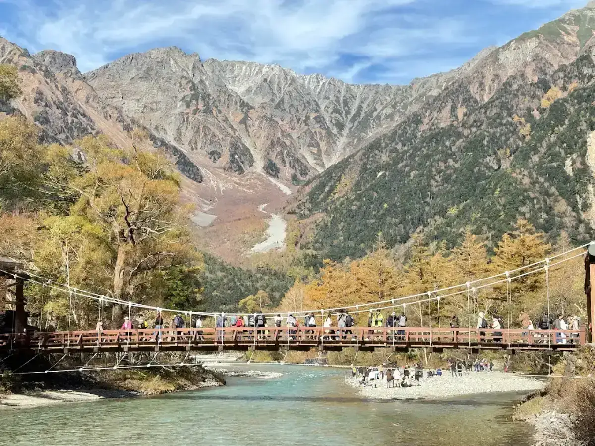 山坡下橫跨碧綠河流的吊橋